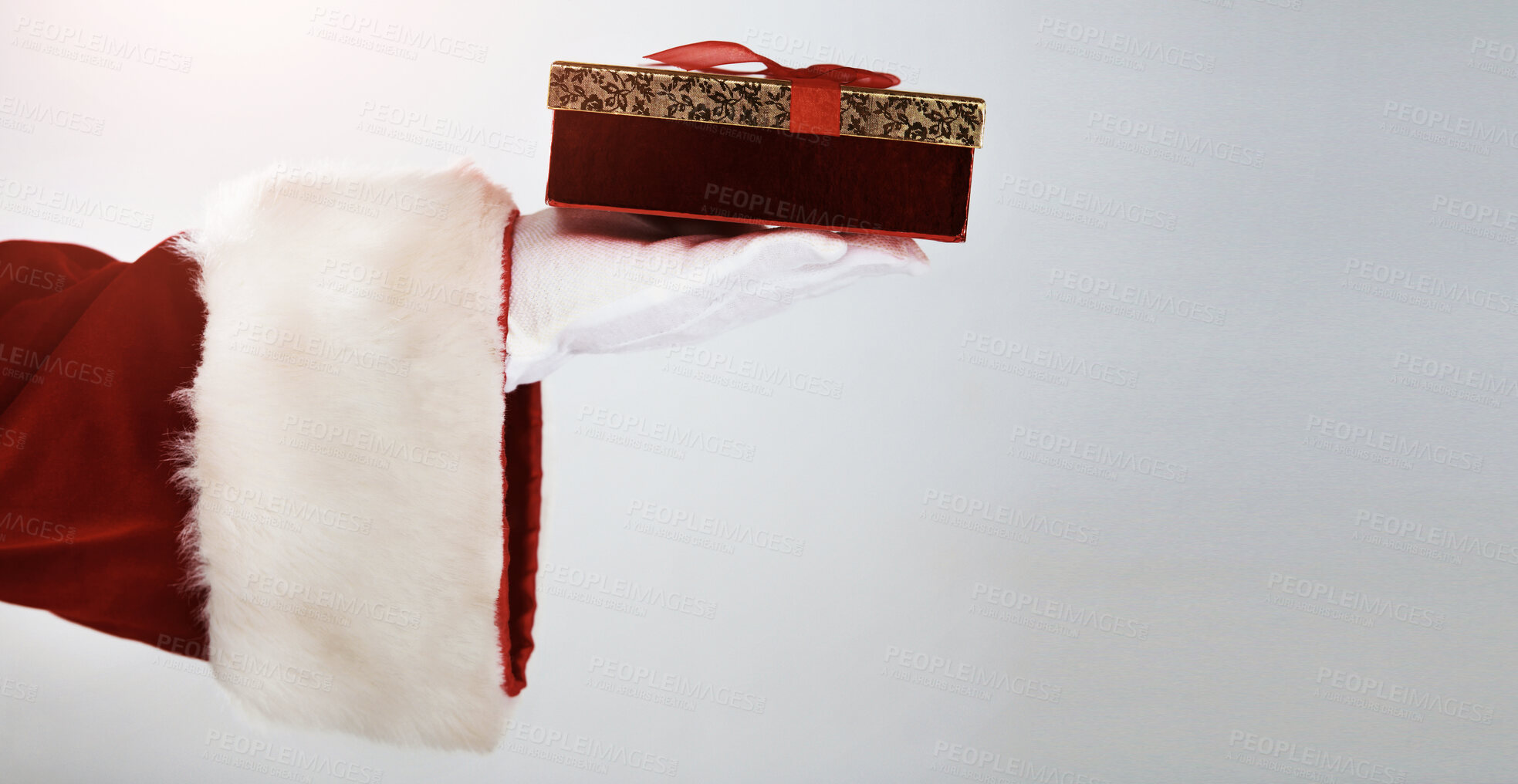 Buy stock photo Cropped image of Santa holding a single present, with bow, in his white gloved hand