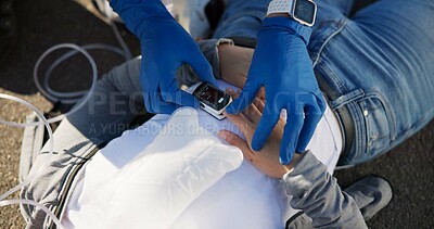 Buy stock photo EMS, hands and heart rate monitor with paramedic on scene of accident to assess victim treatment. First aid, healthcare or medical and emergency service person checking patient on street from above