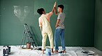 Couple, people and high five with painting wall for house renovations, upgrade and bonding. Home, relationship and happy or smile for fun with support, care and teamwork for love with support