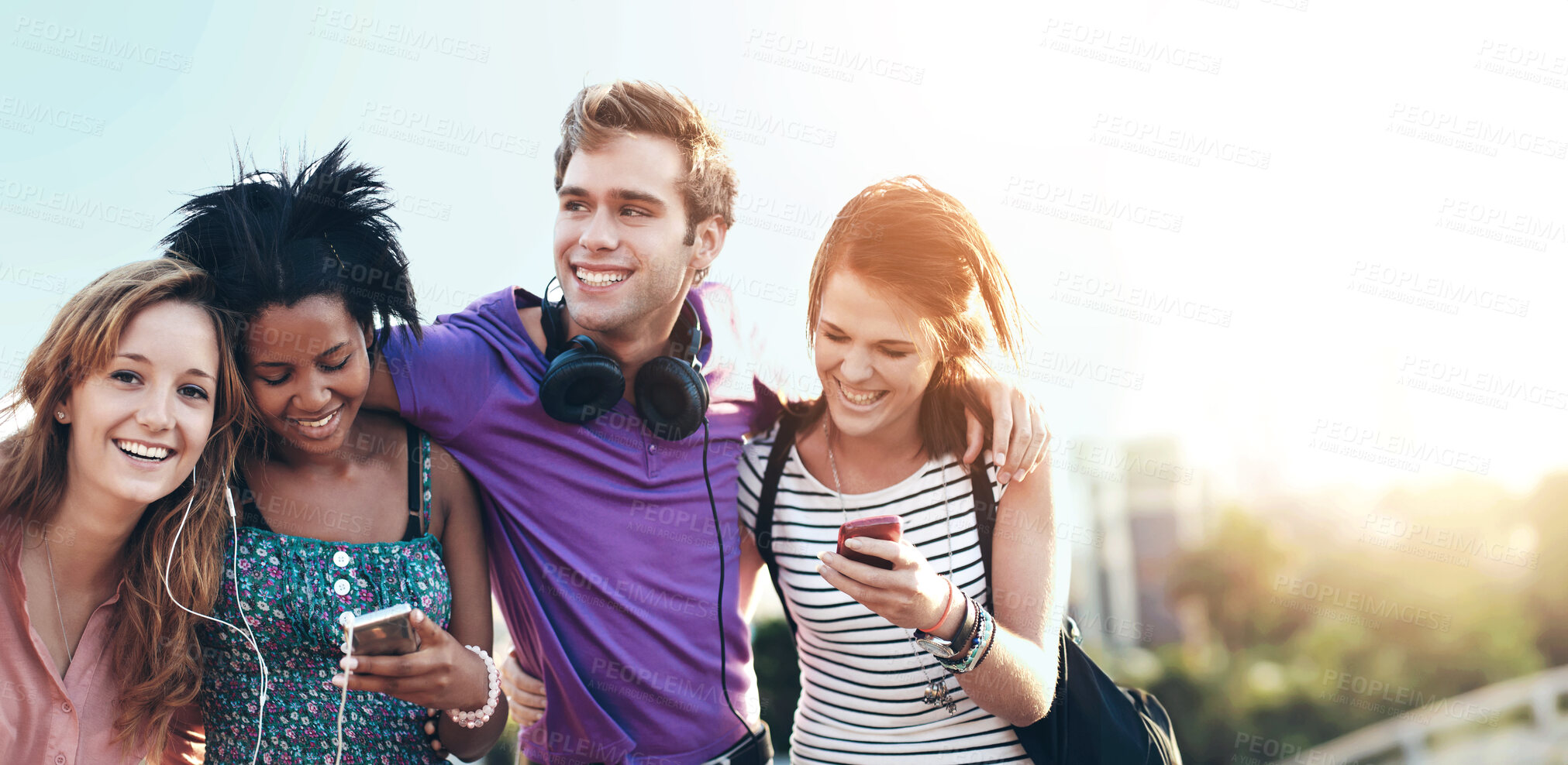 Buy stock photo Closeup of four friends listening to music and typing on their cellphones