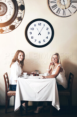 Buy stock photo Two smiling young woman enjoying tea while in a coffee shop - portrait