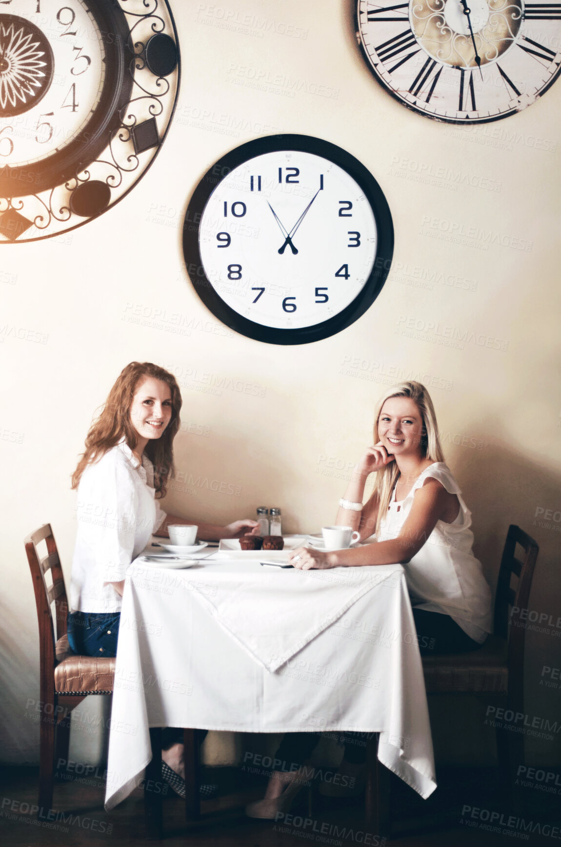 Buy stock photo Two smiling young woman enjoying tea while in a coffee shop - portrait