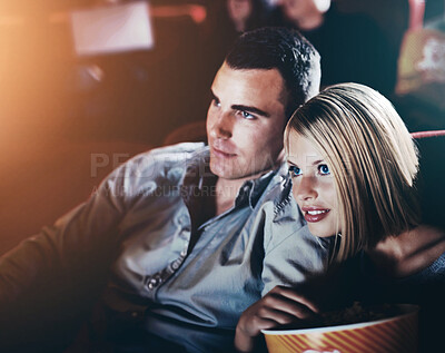 Buy stock photo Date, popcorn and couple at cinema for watching movie, eating or romantic night together. Lens flare, evening and young woman with man in theater with snack for entertainment, show or film premier