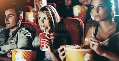 Buy stock photo Friends sitting with refreshments and popcorn enjoying a movie together