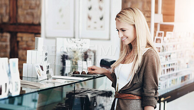 Buy stock photo Woman shopping for chocolate in a candy store with a happy smile for a sale or discount. Customer decide or make a choice on sweets to purchase or buy at food retail  display at a shop or boutique