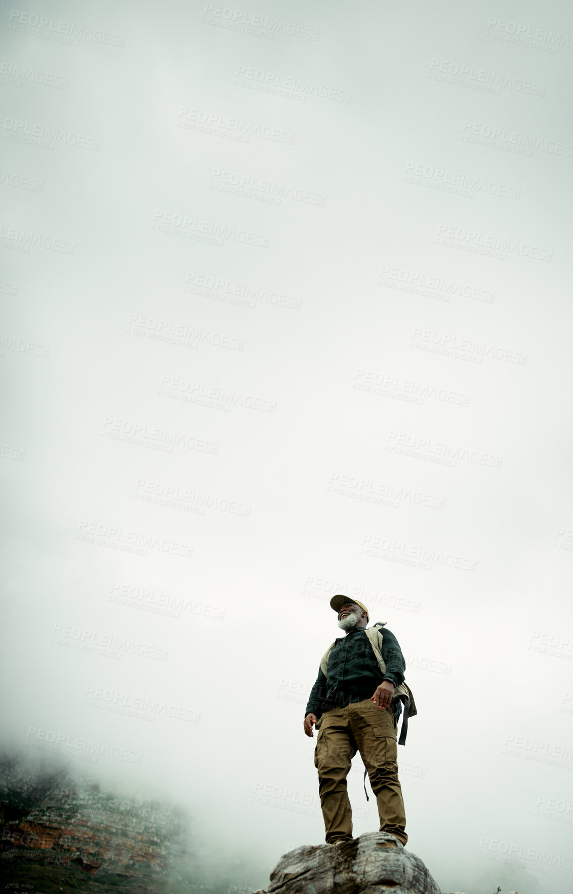 Buy stock photo Clouds, space or black man on peak hiking in outdoor adventure, journey or nature travel for view. Sky mockup, low angle or senior male hiker on mountain for holiday, exercise or trekking to explore