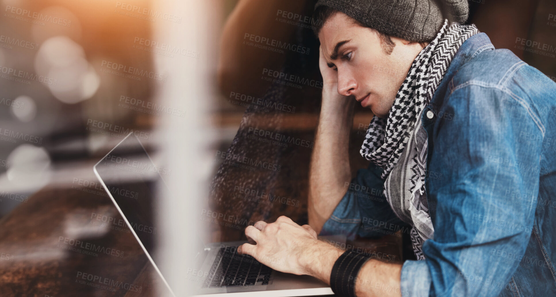 Buy stock photo Shot of a young man sitting at a laptop