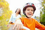 Bike, laughing or learning and boy with mother outdoor on street of neighborhood for child development. Funny, happy or smile with single parent woman teaching son how to ride bicycle in summer