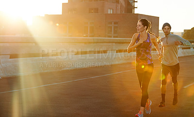 Buy stock photo Running, man and woman in city at sunset for fitness, training and commitment to healthy body. Evening, exercise and athlete couple on road for urban workout, outdoor challenge or sports performance