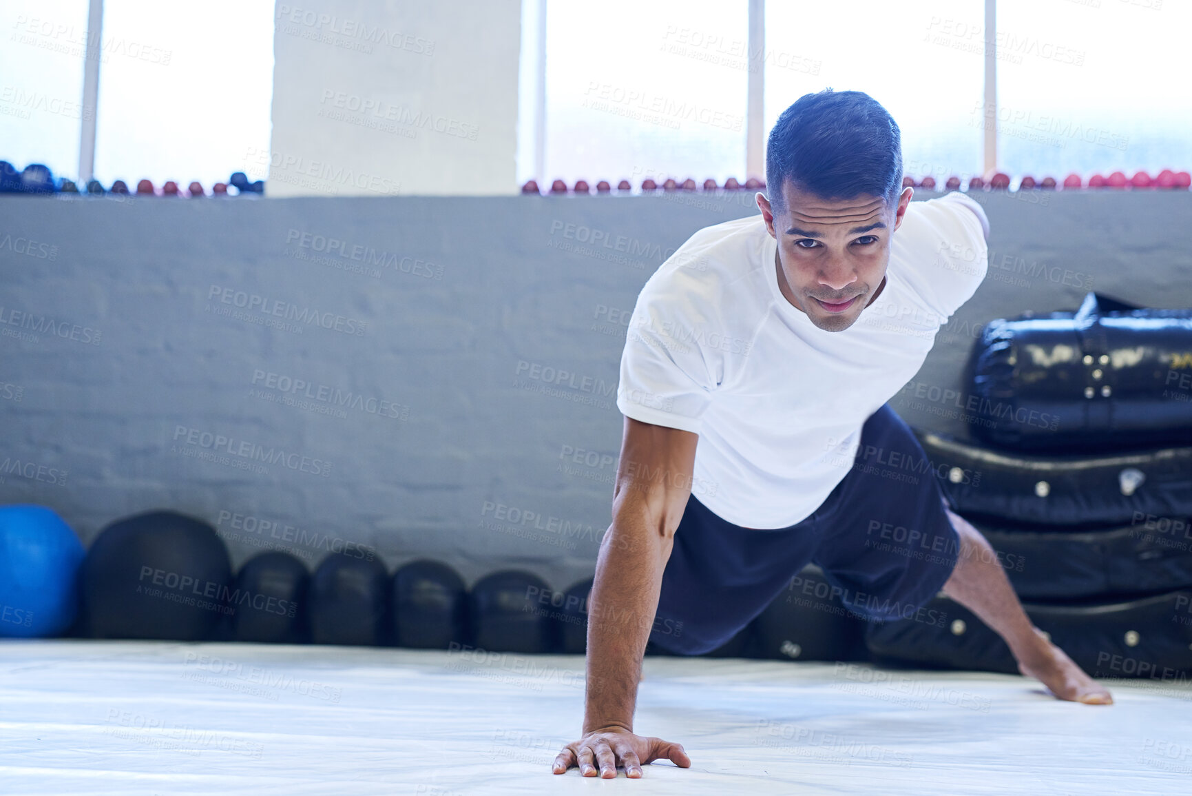 Buy stock photo Fitness, portrait and push up with sports man in gym for commitment to health or wellness. Balance, exercise and workout with confident athlete training for challenge, performance or resilience