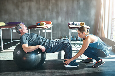 Buy stock photo Shot of a senior man working out with his physiotherapist