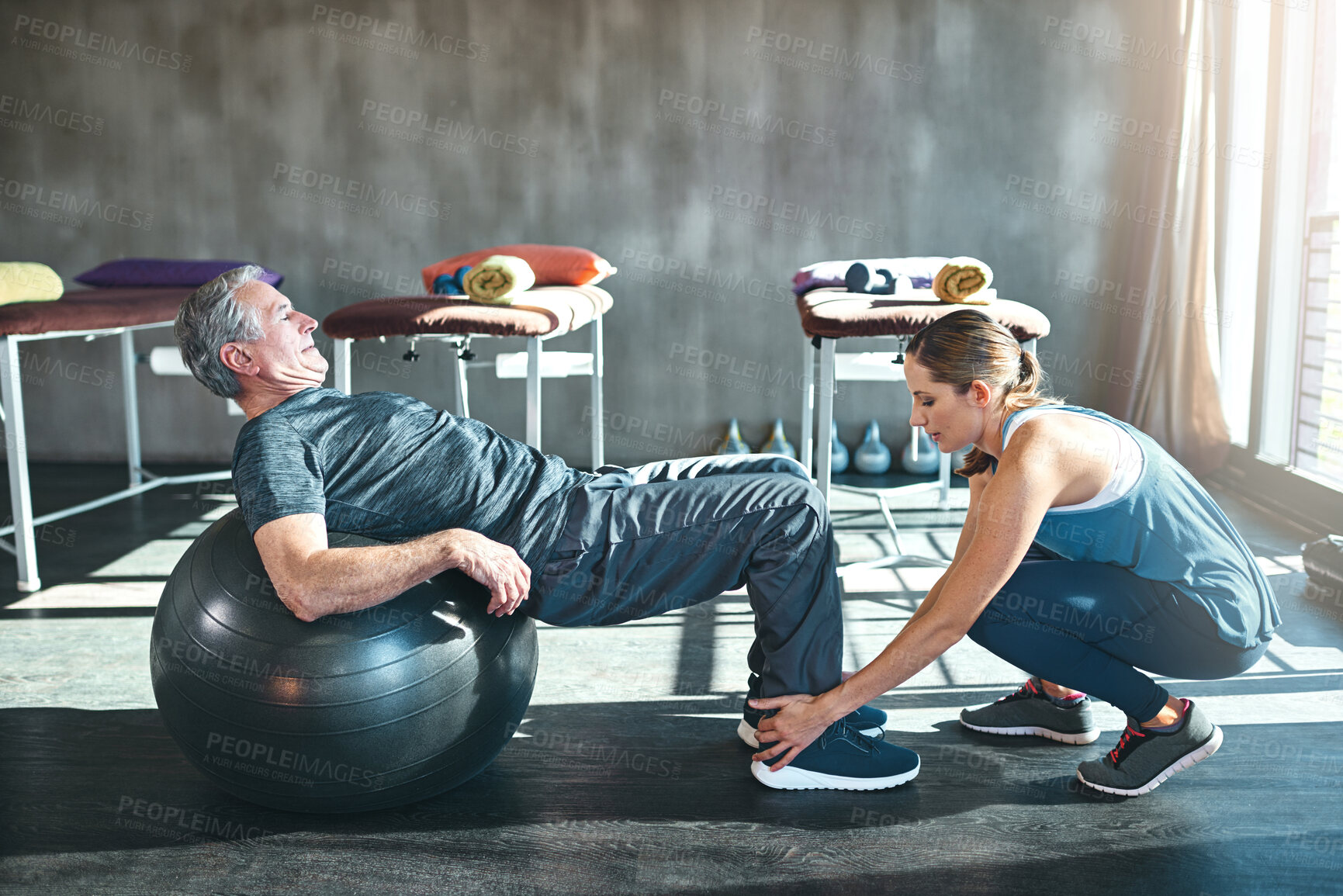 Buy stock photo Shot of a senior man working out with his physiotherapist