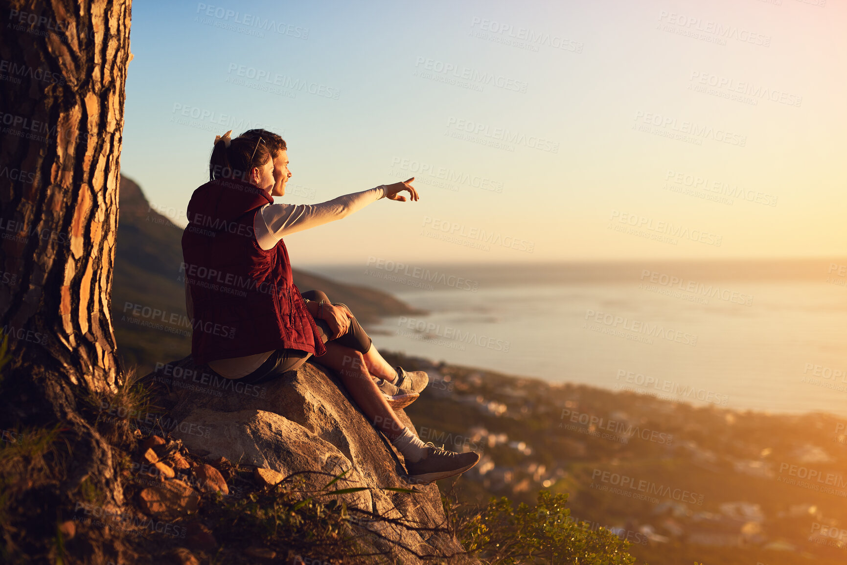 Buy stock photo Couple, rock and outdoor with relax on peak or point for view, adventure and bonding in nature or environment. Man, woman and pointing on mountain for fresh air, peace and horizon with love on trip.