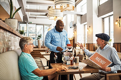 Buy stock photo Shot of two senior friends placing an order with a waiter at their favorite cafe