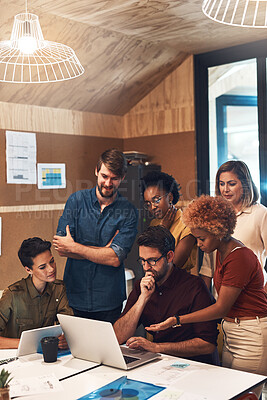 Buy stock photo Shot of a diverse group of businesspeople working together on a laptop in an office