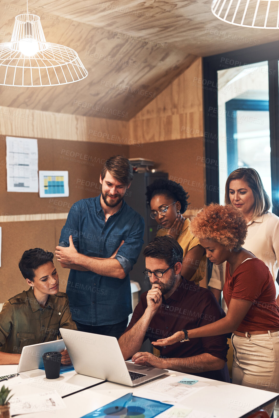 Buy stock photo Shot of a diverse group of businesspeople working together on a laptop in an office