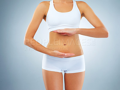 Buy stock photo Woman, underwear and hands by stomach in studio for weight loss, progress and healthy body. Self care, digestion and female person with abdomen on gray background for tummy tuck, results and detox