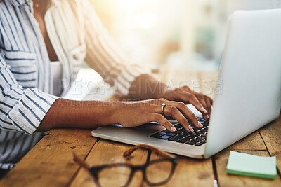 Buy stock photo Cropped shot of a woman using her laptop on a wooden table