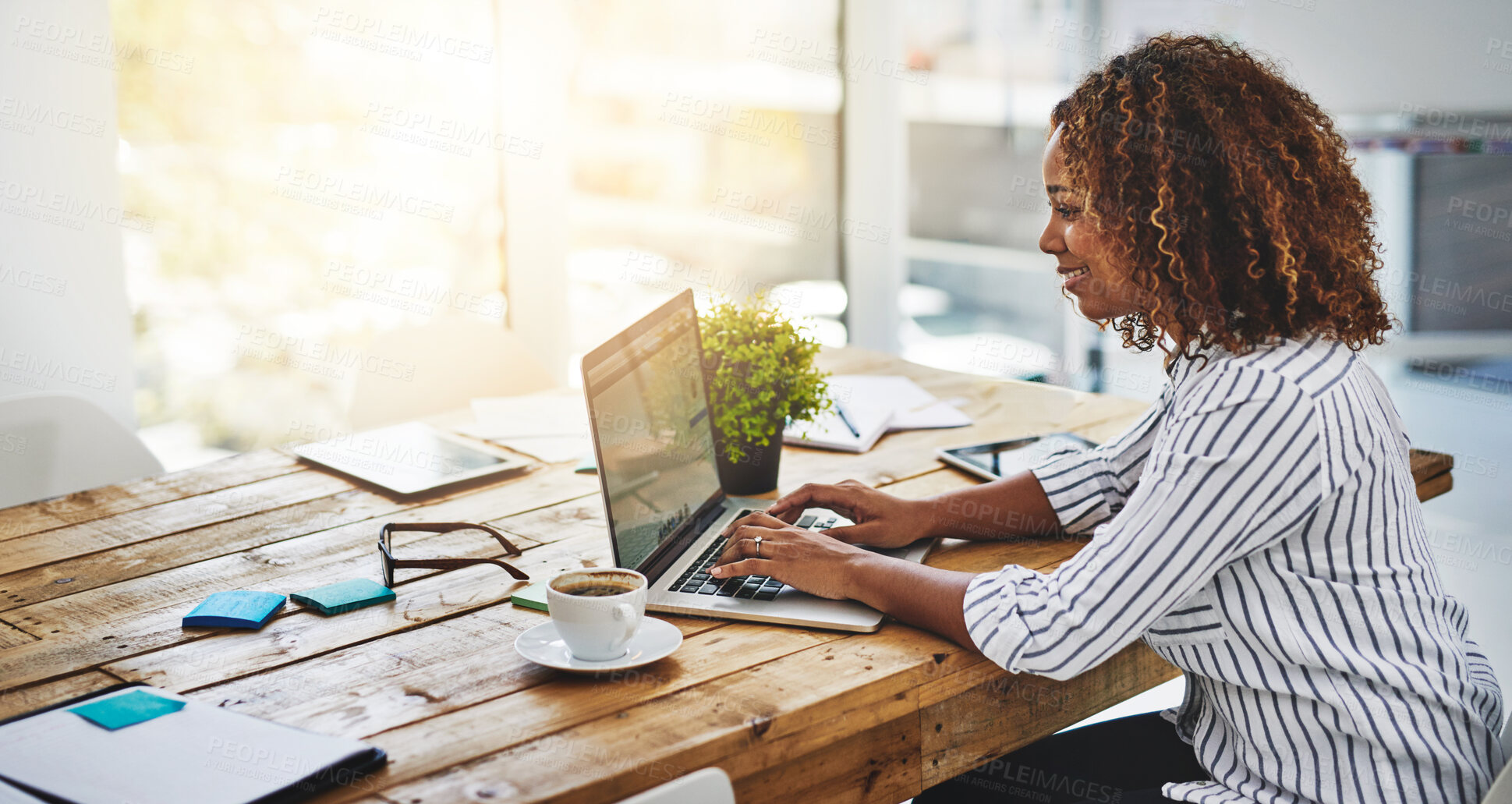 Buy stock photo Cropped shot of a woman using her laptop on a wooden table