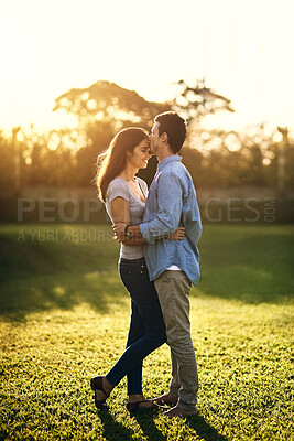 Buy stock photo Kiss, date and happy couple at park for love, care and bonding together outdoor. Romance, man and woman at embrace at garden for commitment, support and connection for healthy relationship on grass