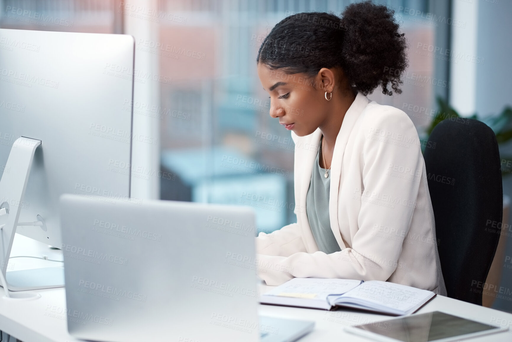 Buy stock photo Shot of a young businesswoman working at her desk in a modern office