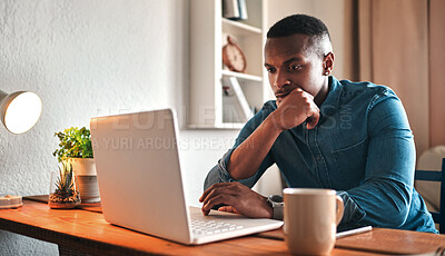 Buy stock photo Cropped shot of a handsome young businessman sitting in his home office and looking contemplative while working on his laptop