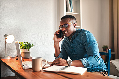 Buy stock photo Cropped shot of a handsome young businessman sitting alone in his home office and talking on his cellphone