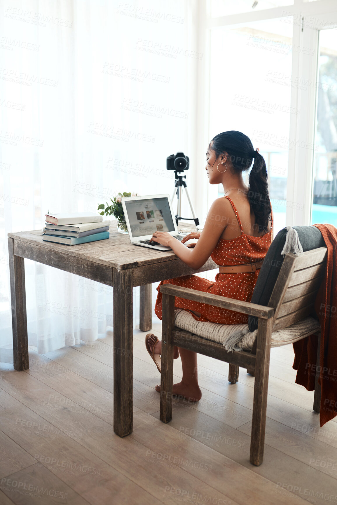 Buy stock photo Full length shot of an attractive young businesswoman sitting in her home office and using her laptop