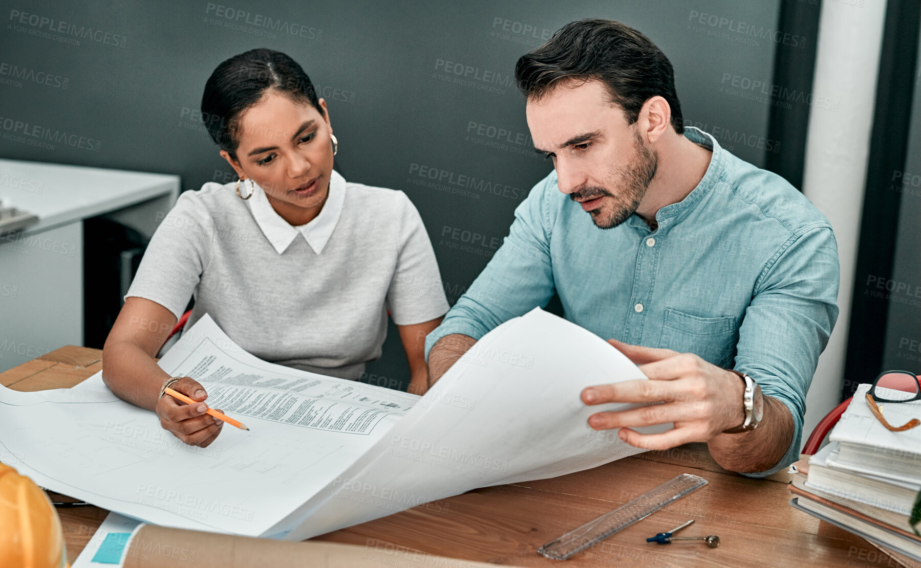 Buy stock photo Shot of two architects working with blueprints in an office