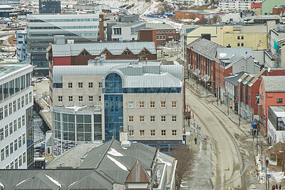 Buy stock photo Aerial view of Bodo city in Norway with a busy main road. A scenic modern urban landscape of streets and buildings near a snowy mountain in winter with copy space. Peaceful rural town from above