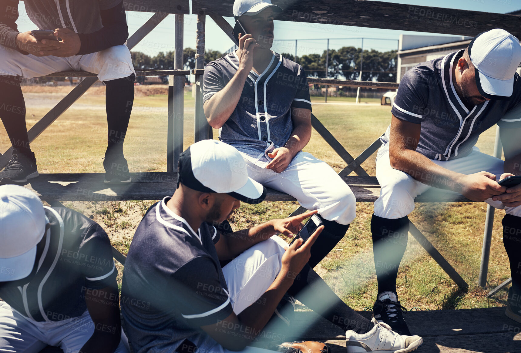 Buy stock photo Baseball player, men and team with smartphone on field, break and relax at stadium with texting on social media. People, group and tired from game, contest and training with phone app in Los Angeles