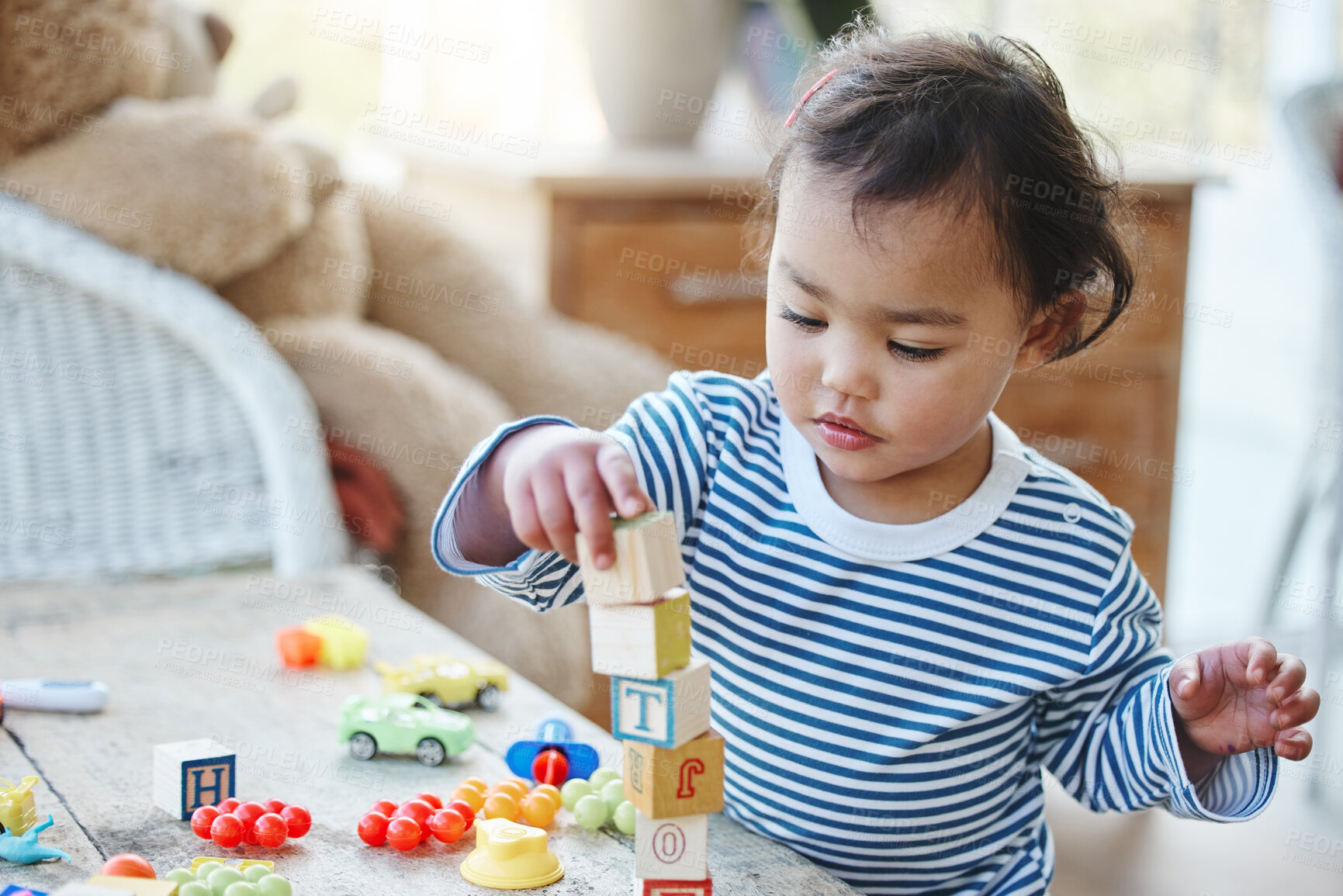 Buy stock photo Baby girl, table and playing with blocks or toys for playful time, chilldhood or development at home. Little child or cute toddler enjoying youth and stacking cubes, squares or building at house