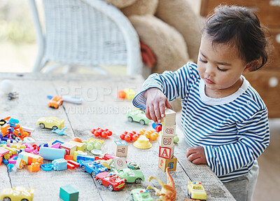 Buy stock photo Baby girl, table and stacking with blocks or toys for playful time, chilldhood or development at home. Little child or cute toddler enjoying youth and playing with cubes, squares or building at house