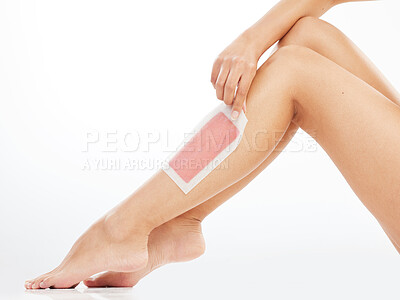 Buy stock photo Woman, leg and wax strip in studio, hair removal and healthy skincare on white background. Body wellness, hand and pull cosmetic product for grooming routine, smooth skin and pedicure feet for beauty