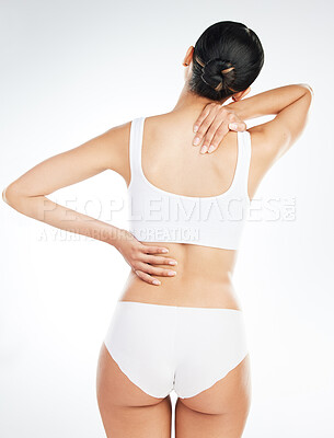 Buy stock photo Back pain, underwear and woman in studio with injury, muscle inflammation or tension on white background. Rear view, health emergency and model with spine problem for sprain, discomfort or wellness