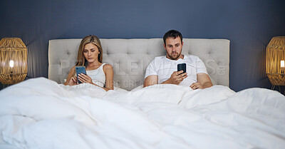 Buy stock photo Phone, relax and couple in bed for scroll on social media, online or networking at night. Upset, rest and young man and woman laying in bedroom with cellphone for communication in argument at home.