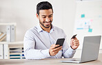 Young mixed race happy businessman using a credit card and phone to shop online at work. One hispanic man paying for a purchase using his cellphone. Man buying products using his phone and bank card