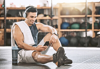 Buy stock photo Fitness, man and relax in gym with smartphone for music, exercise tracker and apps for workout progress. Male person, happy and headphones for training playlist, audio and online for cardio tips.