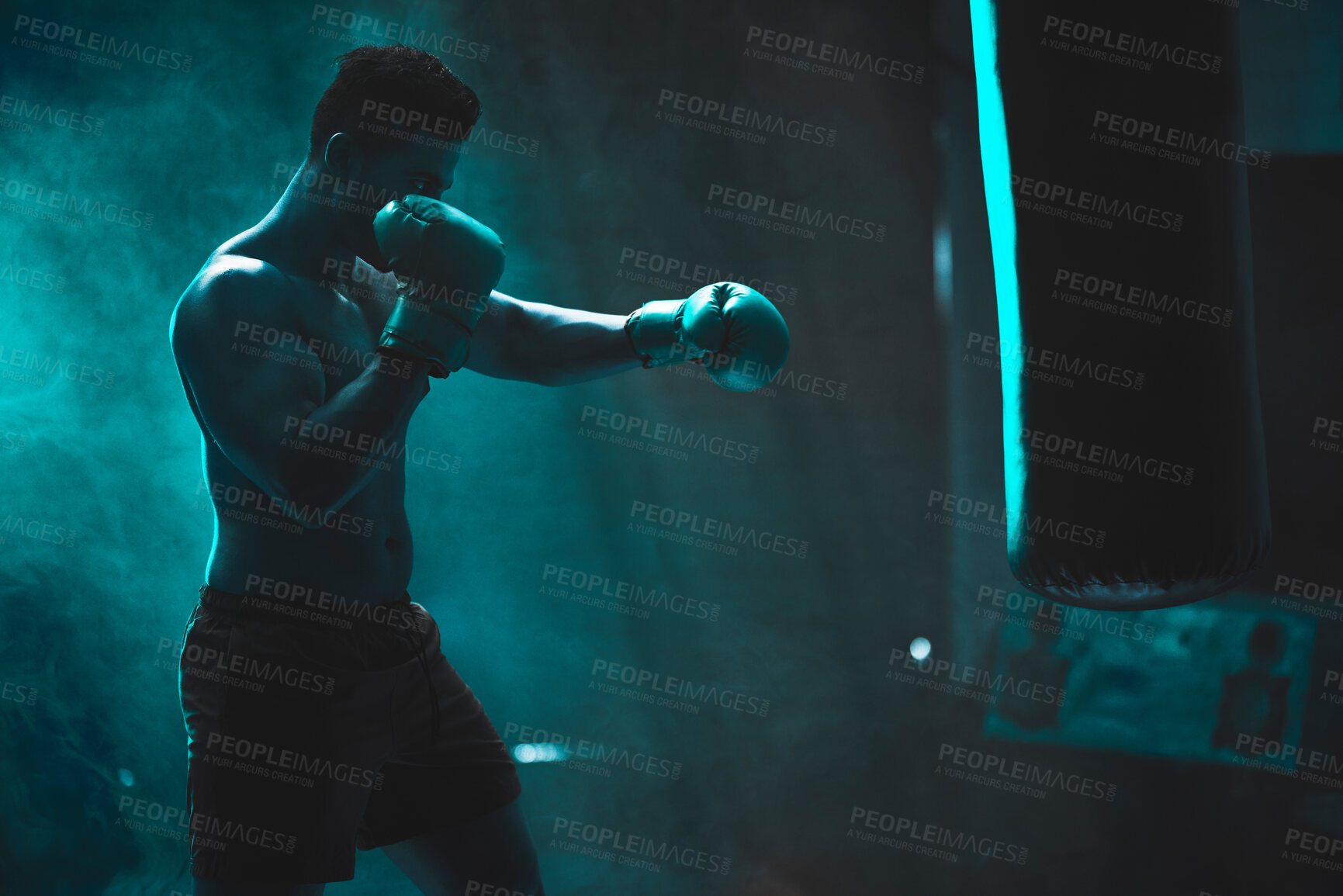 Buy stock photo Man, punching bag and fitness exercise at gym, training practice and attack challenge for combat. Male person, neon and dojo club aesthetic for boxing competition, athlete and martial arts workout