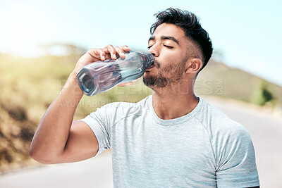 Buy stock photo Fitness, man and drinking water in nature for health, wellness an hydration in day. Thirsty, liquid and athlete with bottle for detox, natural nutrition and minerals on road for exercise and training