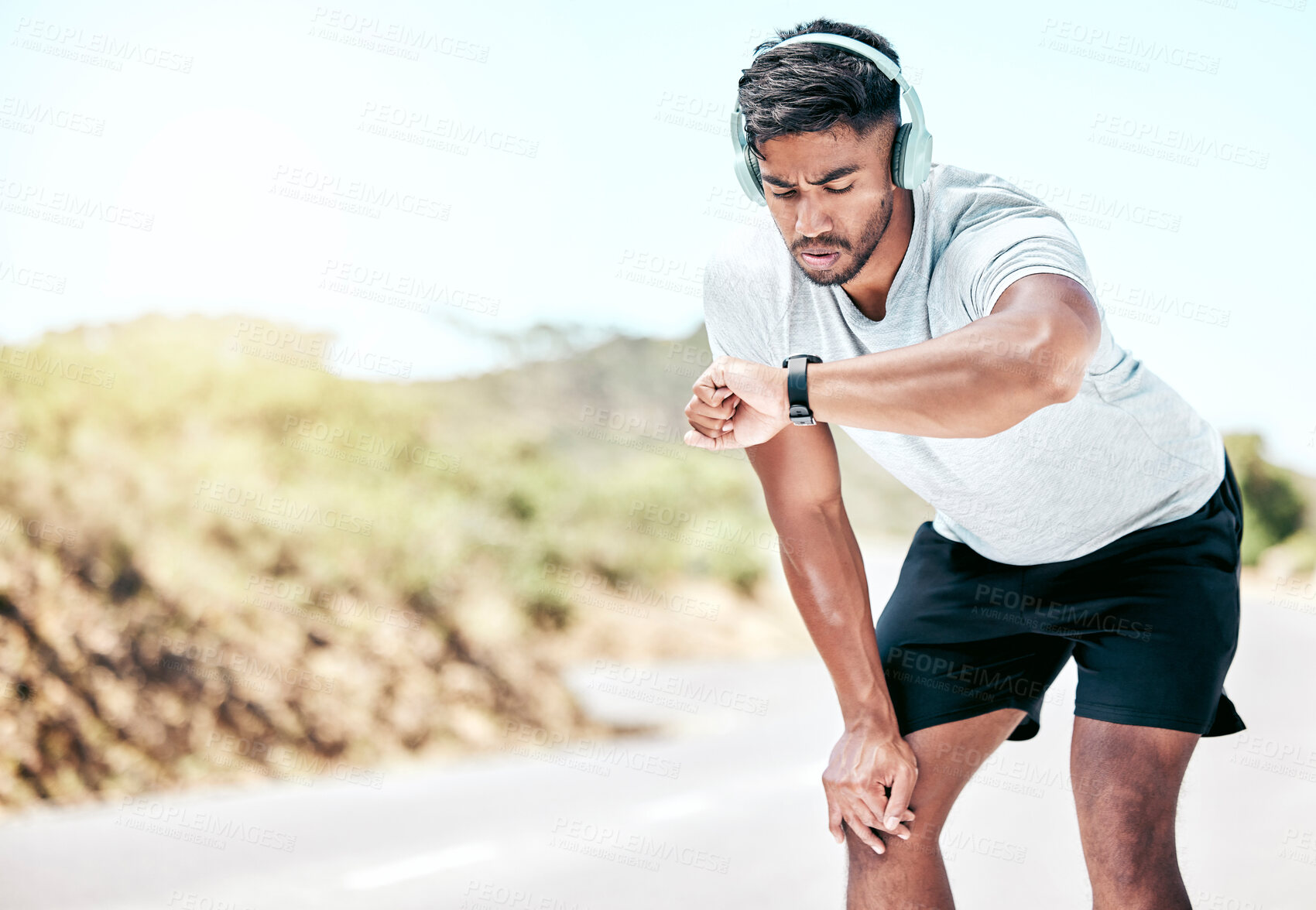 Buy stock photo Outdoor, man and headphones with digital watch on break to monitor or tracking health, wellness and wellbeing. Male person, jogging and music with running results, heart rate on exercise app