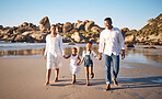 Happy young african american family with two children holding hands and having fun while walking along beach. Loving parents enjoying vacation with cheerful little daughter and son