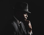 Dapper and confident young man dressed in formal attire against a dark background. Handsome african american male looking stylish and sophisticated isolated on black. Looking very classy and debonair