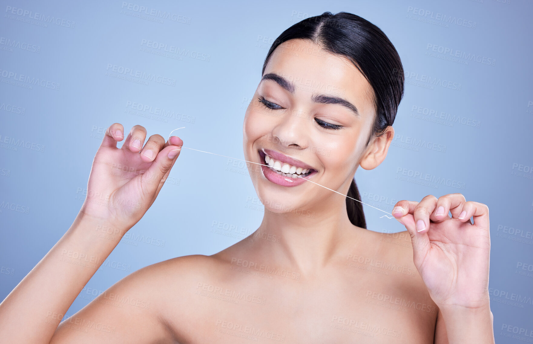 Buy stock photo Dental, smile or happy woman flossing for cleaning or oral hygiene in studio on blue background. String, dentistry or model with tooth care product or thread to prevent cavity, decay or gum disease