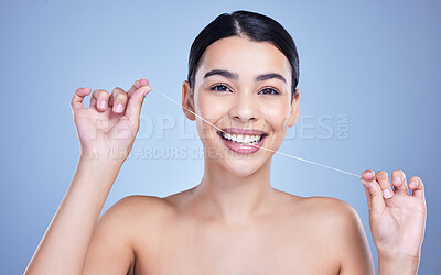 Buy stock photo Dental floss, smile or portrait of happy woman for cleaning or oral hygiene in studio on blue background. String, dentistry or model with tooth care product to prevent cavity, decay or gum disease