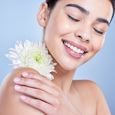 Buy stock photo Flower, relax or woman with smile or natural beauty on blue background with herbs, pride and glow. Face, happy or girl model in studio with floral cosmetics, plants or skincare for facial results