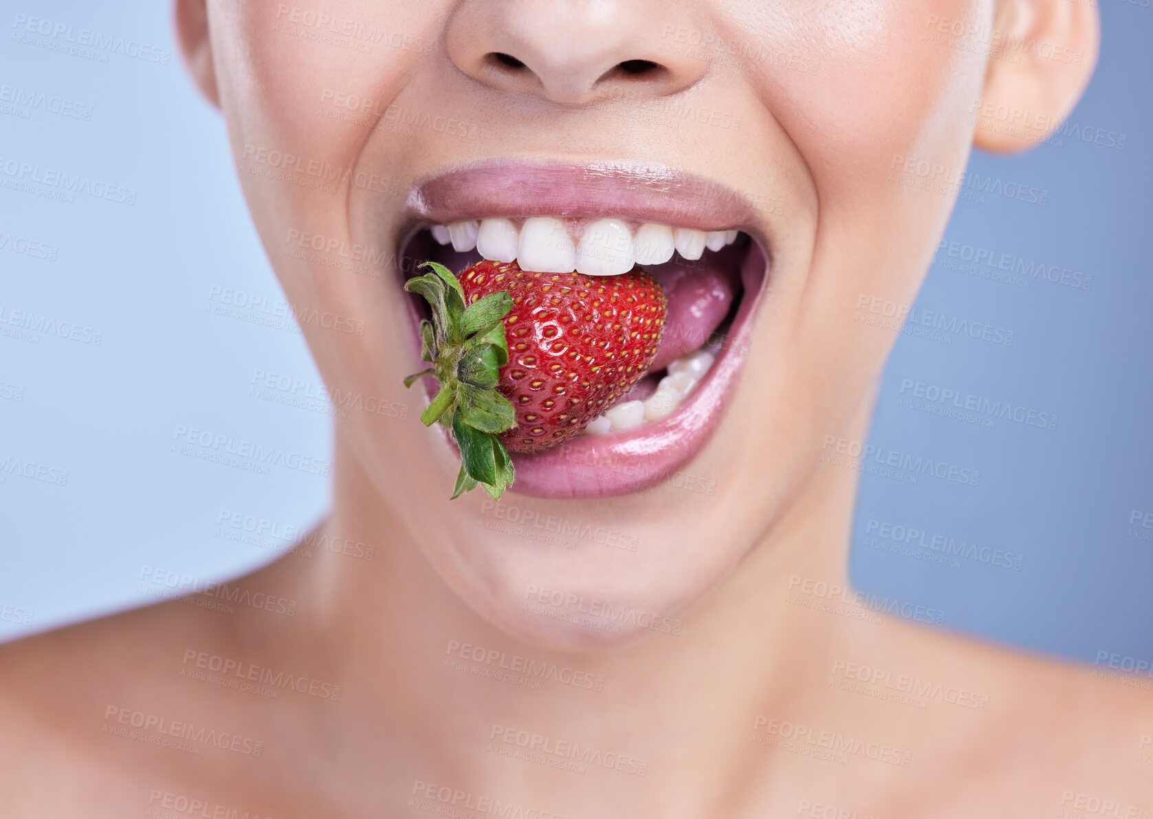 Buy stock photo Beauty, woman and mouth with eating strawberry in studio for skincare, anti aging benefits or vitamin c for glowing skin. Model, girl and fruit for nutrition, health and wellness on blue background