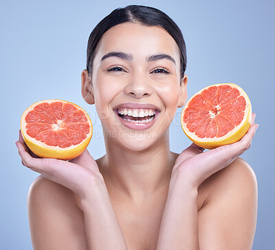 Buy stock photo Woman, grapefruit and portrait in studio for skincare, organic or natural cosmetic with vitamin c or citrus acid. Girl, happy and fruit on blue background for eco friendly, detox or healthy glow