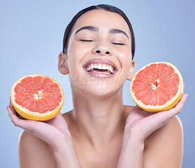 Buy stock photo Girl, grapefruit and happy in studio for skincare, organic and natural cosmetic with vitamin c or smile. Woman, eyes closed and fruit on blue background for sustainability, detox and healthy glow.