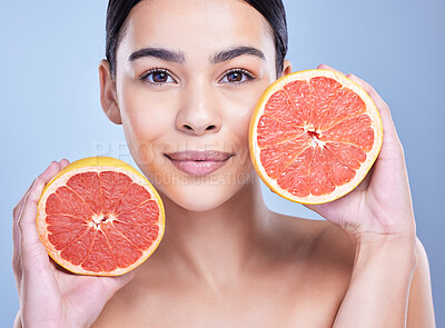 Buy stock photo Girl, grapefruit and happy with portrait for skincare in studio, organic and natural cosmetic with vitamin c or citrus acid. Woman, fruit and blue background for benefits, detox and healthy glow.